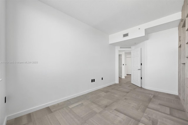 spare room featuring visible vents and baseboards