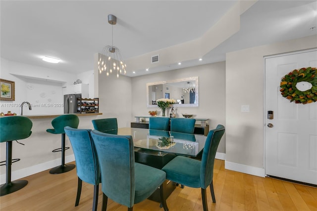 dining area with baseboards, visible vents, and wood finished floors