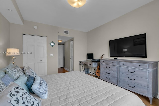 bedroom featuring a closet, visible vents, and wood finished floors