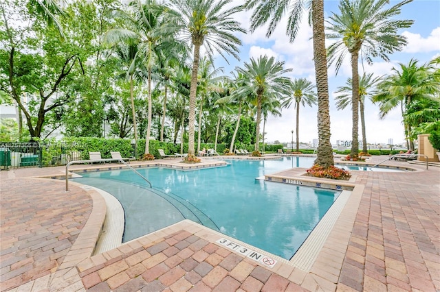 community pool featuring a patio area and fence