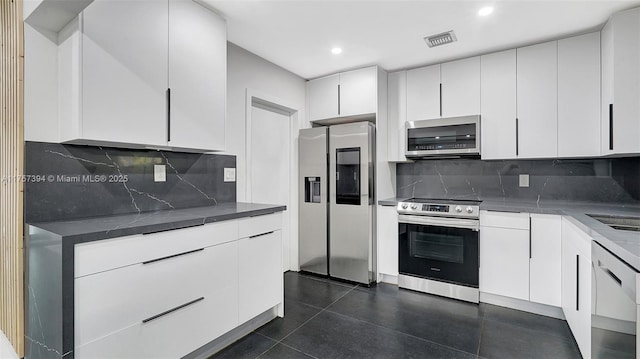 603 N 32nd Ave, Hollywood, FL 33021 - kitchen featuring dark countertops, visible vents, stainless steel appliances, and white cabinets