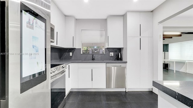 603 N 32nd Ave, Hollywood, FL 33021 - kitchen with backsplash, appliances with stainless steel finishes, white cabinets, a sink, and modern cabinets
