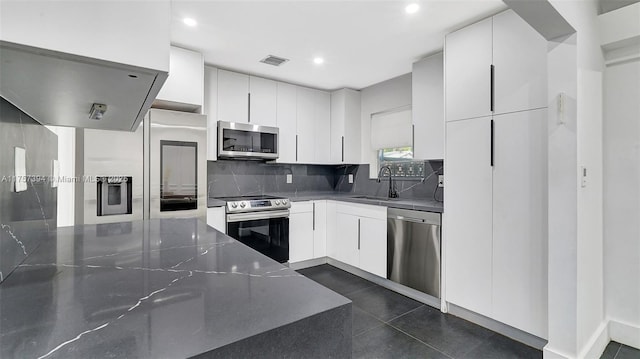 603 N 32nd Ave, Hollywood, FL 33021 - kitchen featuring visible vents, decorative backsplash, appliances with stainless steel finishes, white cabinets, and a sink