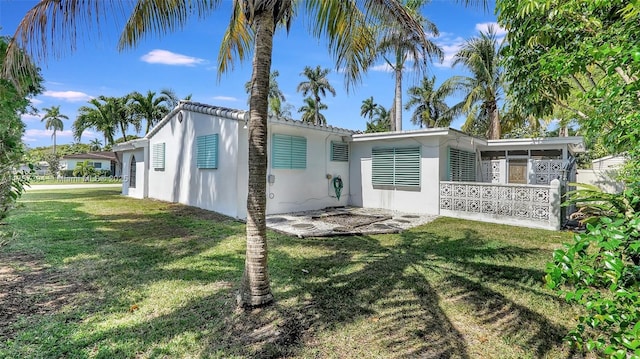 603 N 32nd Ave, Hollywood, FL 33021 - rear view of house with a yard, a sunroom, and stucco siding