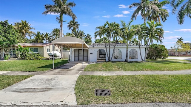 603 N 32nd Ave, Hollywood, FL 33021 - view of front facade with a front yard, stucco siding, driveway, and a detached carport