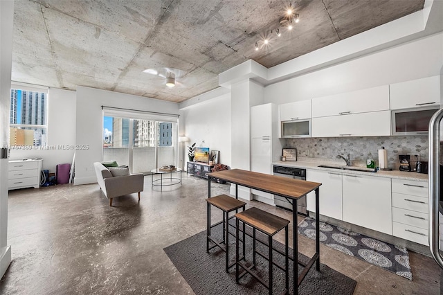 kitchen featuring a sink, white cabinets, light countertops, dishwasher, and tasteful backsplash