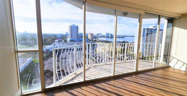 unfurnished sunroom featuring a water view and a view of city