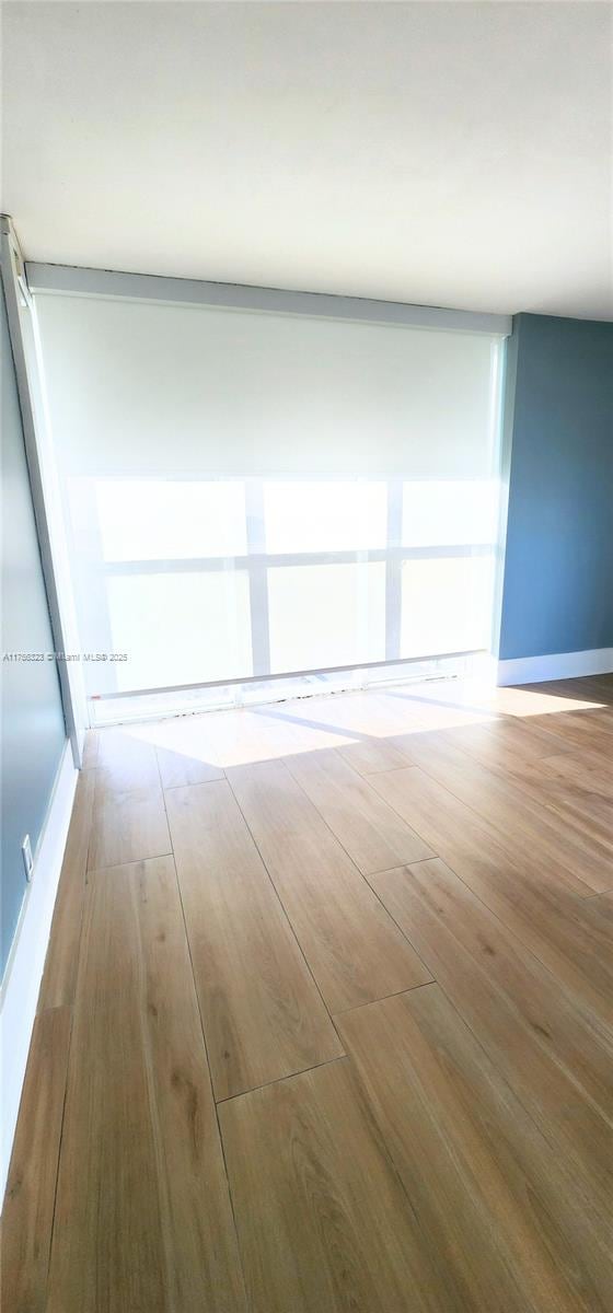 unfurnished room featuring wood finished floors and baseboards