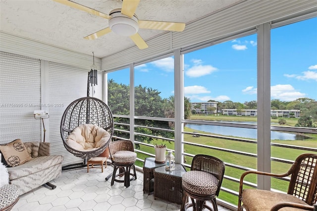 sunroom / solarium featuring a water view and ceiling fan