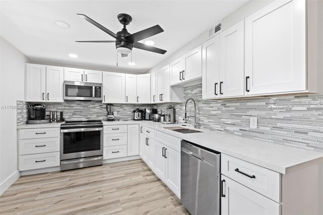 kitchen featuring appliances with stainless steel finishes, visible vents, a sink, and white cabinetry