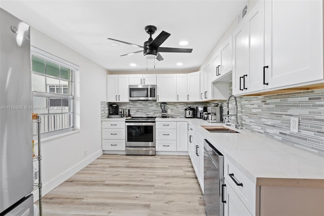 802 Cypress Grove Ln Unit 409, Pompano Beach, FL 33069 - kitchen with stainless steel appliances, a sink, a ceiling fan, light wood-style flooring, and tasteful backsplash