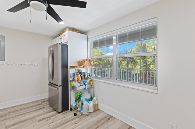 kitchen with light wood-style floors, baseboards, white cabinets, and freestanding refrigerator