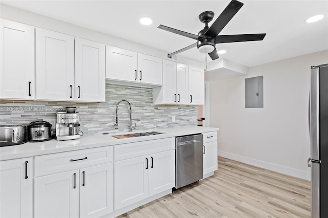 kitchen featuring a sink, light wood-style floors, light countertops, appliances with stainless steel finishes, and electric panel