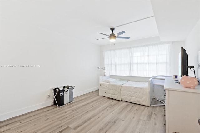 bedroom featuring ceiling fan, baseboards, and wood finished floors