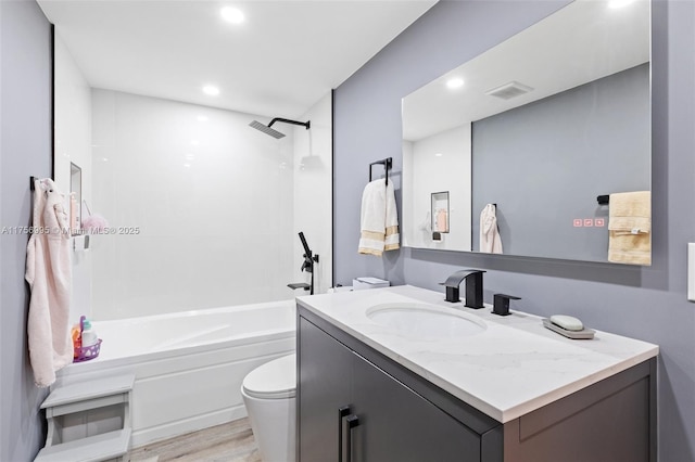 bathroom featuring bathing tub / shower combination, visible vents, toilet, vanity, and wood finished floors