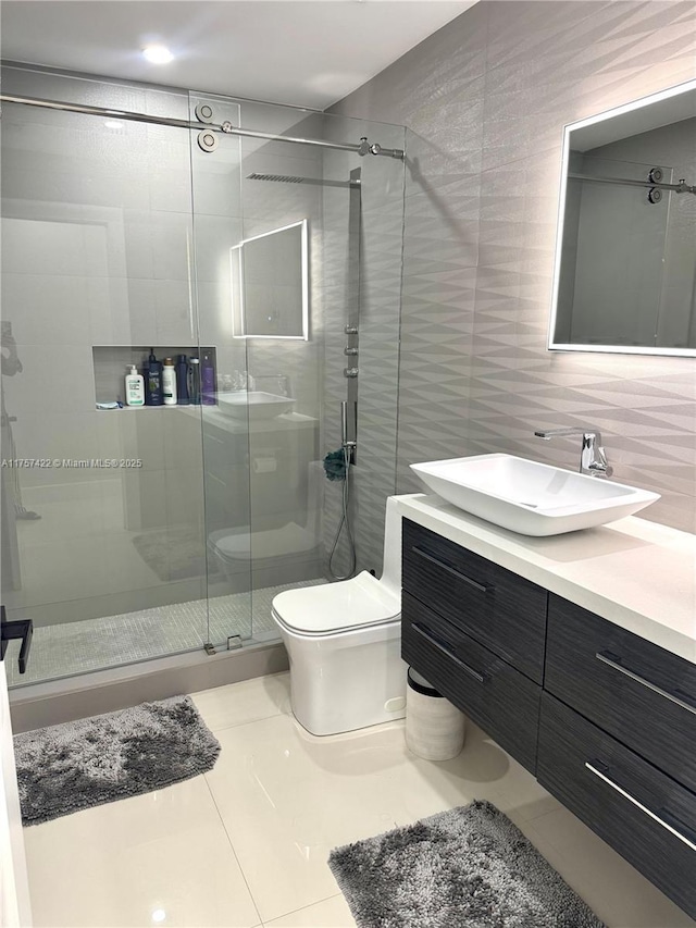 bathroom with tile walls, backsplash, toilet, a shower stall, and vanity