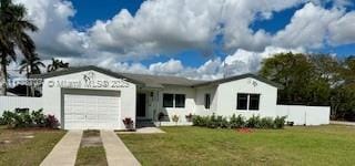 view of front facade featuring an attached garage, driveway, and a front lawn