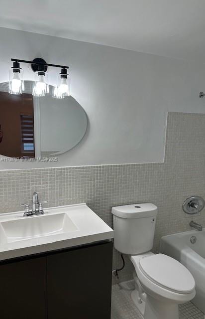 bathroom featuring shower / tub combination, toilet, vanity, tile walls, and tile patterned floors