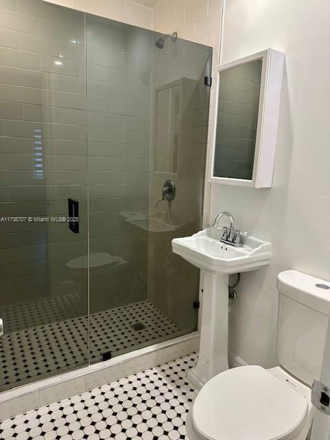 bathroom with a stall shower and toilet