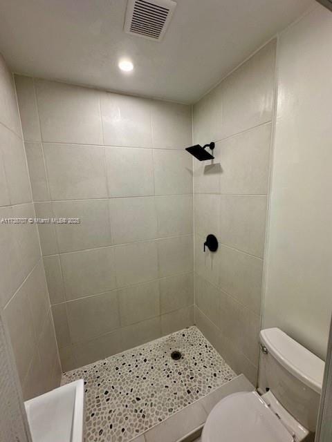 full bathroom with visible vents, a shower stall, and toilet