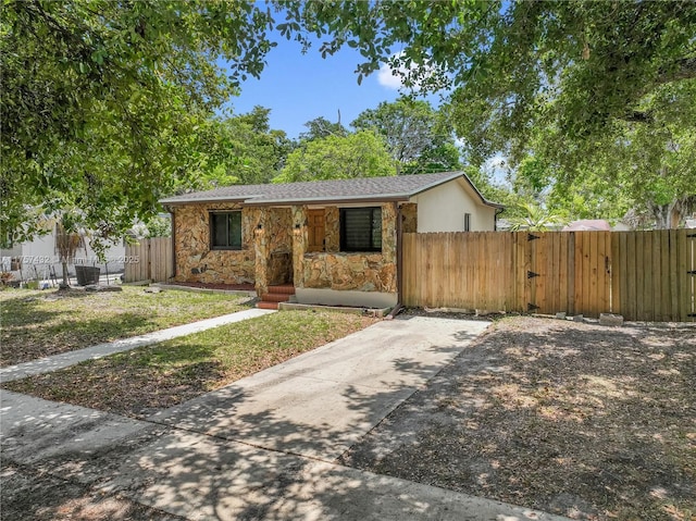 6444 Mcclellan St, Hollywood, FL 33024 - view of front of home featuring stone siding, fence, and covered porch