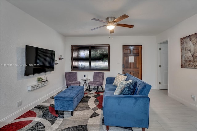 living room featuring baseboards and a ceiling fan