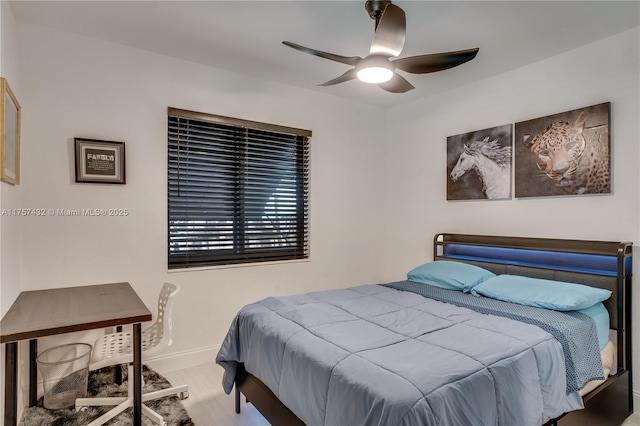 bedroom with wood finished floors, a ceiling fan, and baseboards