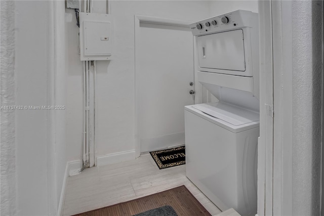 6444 Mcclellan St, Hollywood, FL 33024 - laundry room featuring estacked washer and dryer, electric panel, wood finished floors, and baseboards
