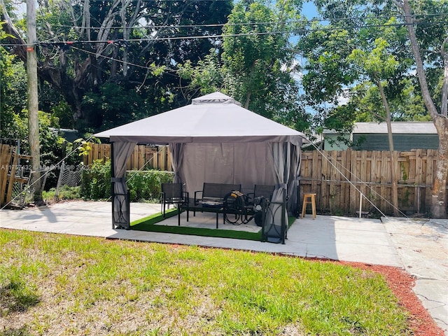 view of yard featuring a patio, an outdoor hangout area, a gazebo, and fence