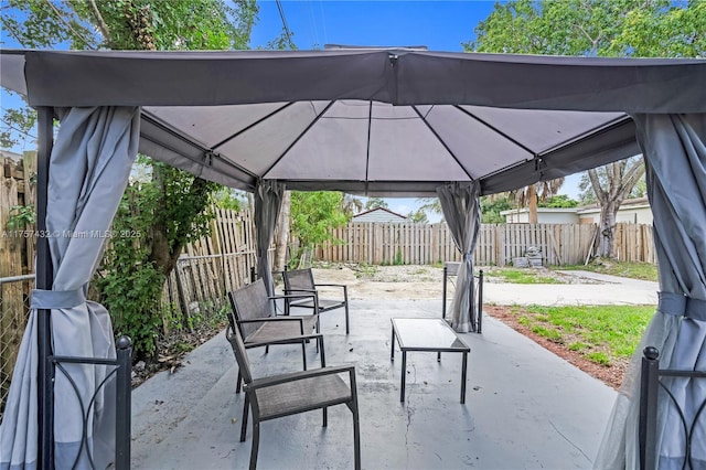 view of patio featuring a fenced backyard, a detached carport, and a gazebo