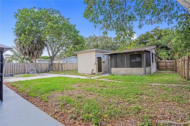 view of yard featuring a fenced backyard and a sunroom