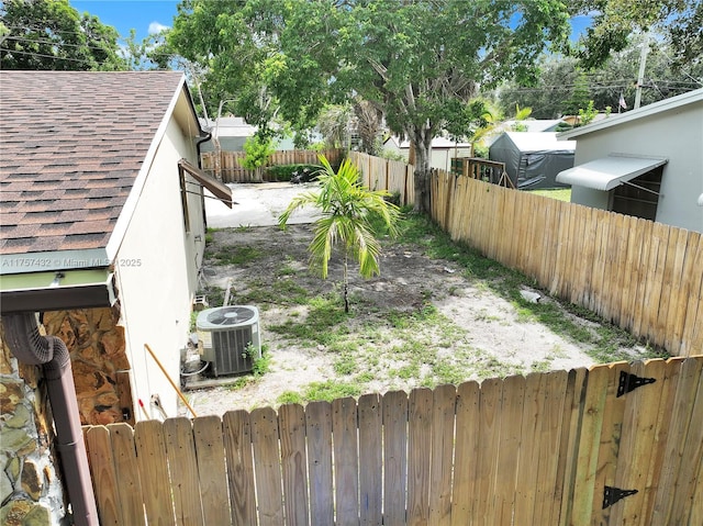 view of yard with a fenced backyard and central air condition unit