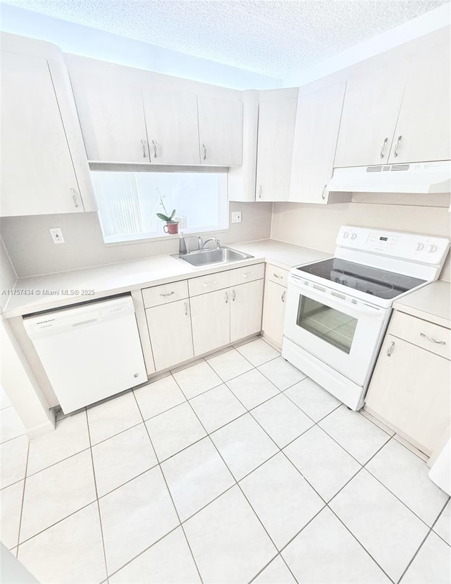 kitchen featuring white appliances, light countertops, under cabinet range hood, and a sink