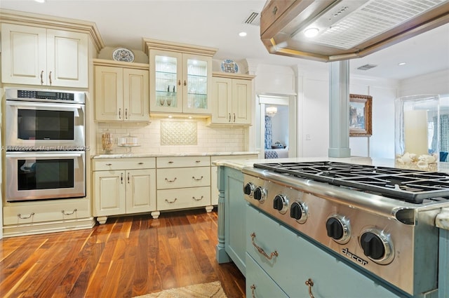 kitchen featuring cream cabinetry, appliances with stainless steel finishes, visible vents, and dark wood-style flooring