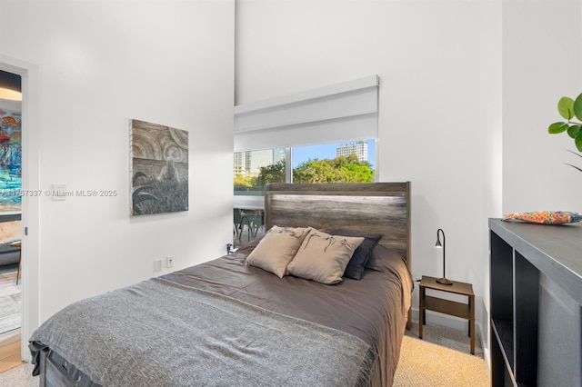 carpeted bedroom featuring a towering ceiling