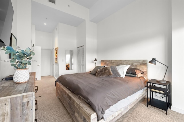 carpeted bedroom featuring visible vents and a towering ceiling