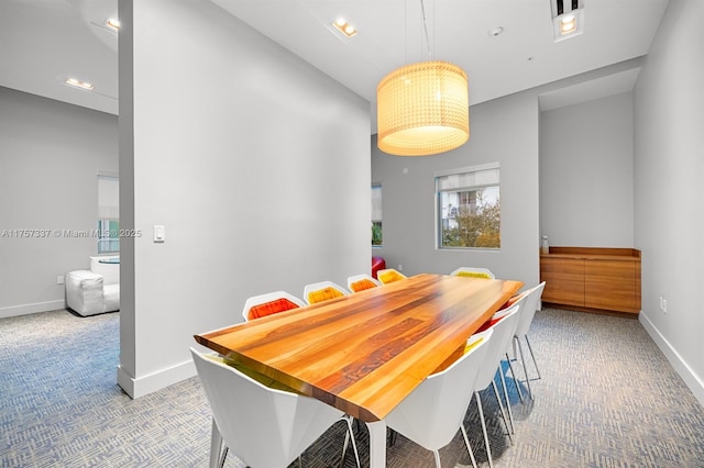 dining area featuring carpet flooring and baseboards