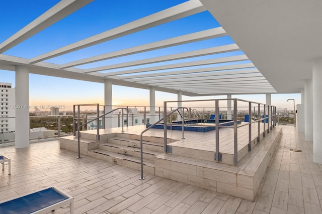 patio terrace at dusk featuring a jacuzzi