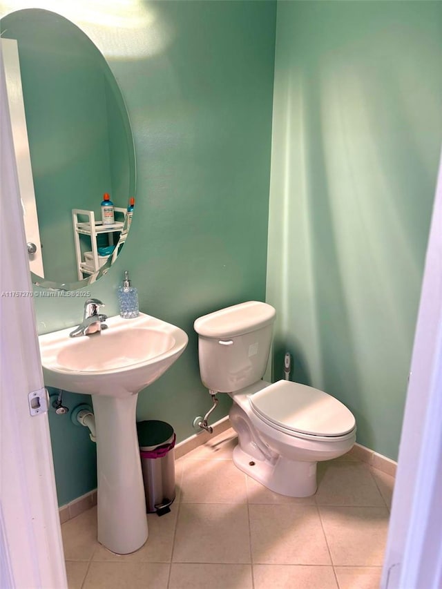 bathroom with baseboards, toilet, and tile patterned floors