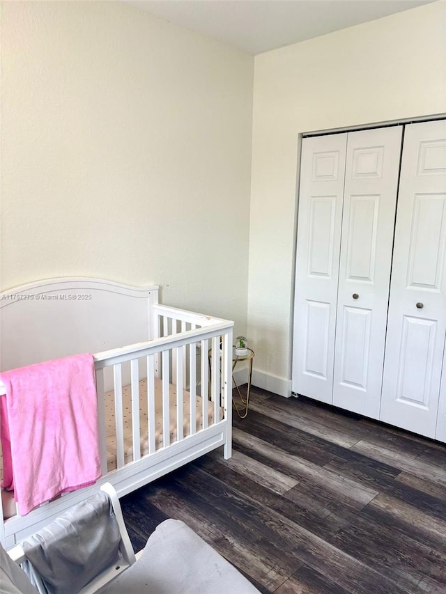 bedroom featuring a closet, baseboards, and wood finished floors