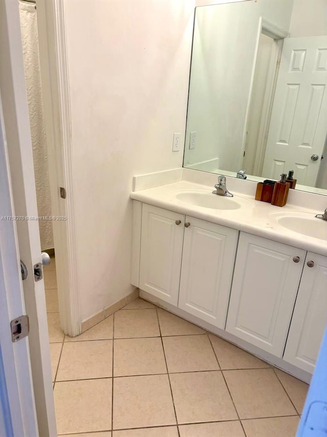 full bathroom with tile patterned flooring, a sink, and double vanity