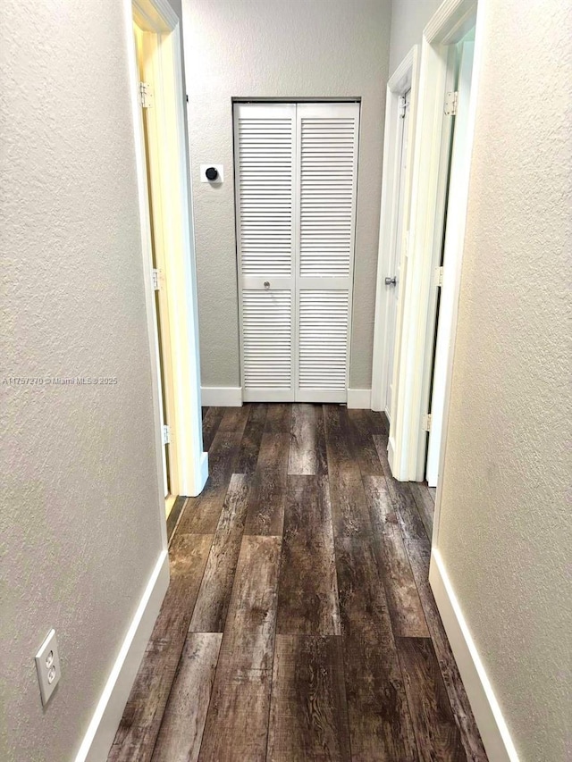 hall with a textured wall and hardwood / wood-style floors