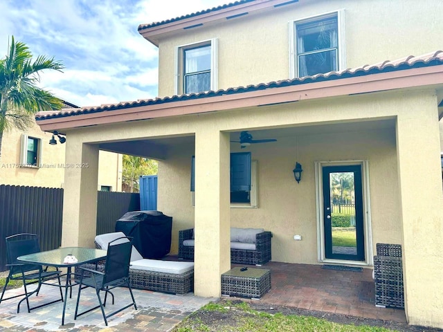 exterior space featuring stucco siding, fence, outdoor dining area, and a patio