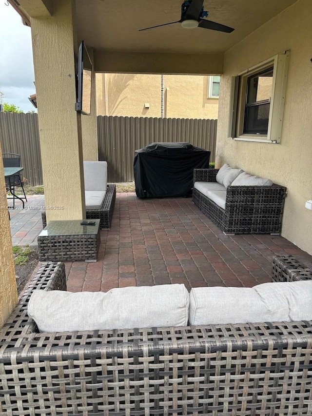 view of patio featuring an outdoor living space, fence, and a ceiling fan