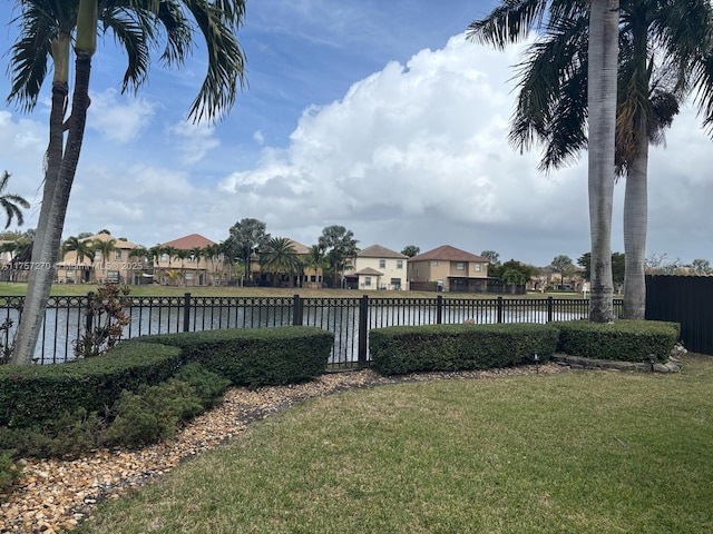 view of yard featuring a water view and fence