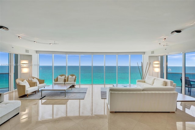 living room with a healthy amount of sunlight, visible vents, a wall of windows, and track lighting