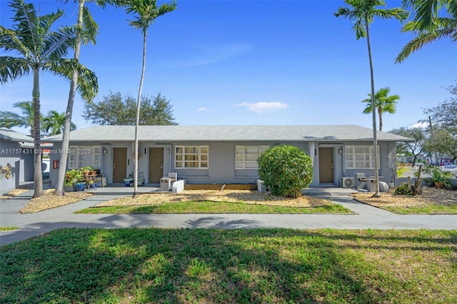 view of front of home featuring a front yard and stucco siding