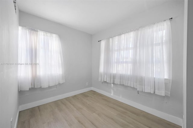 unfurnished room featuring wood finished floors and baseboards