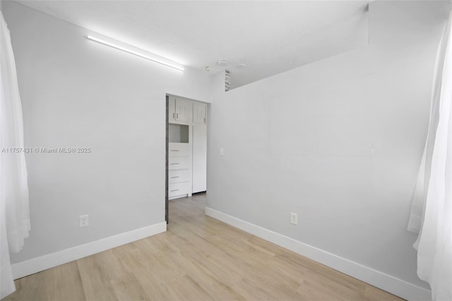 unfurnished room featuring baseboards and wood finished floors