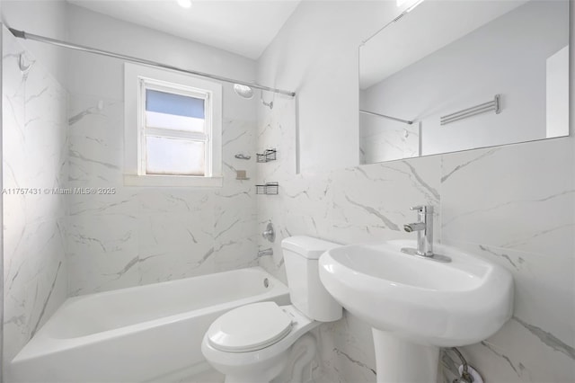 full bath featuring toilet, a sink, tile walls, and bathing tub / shower combination